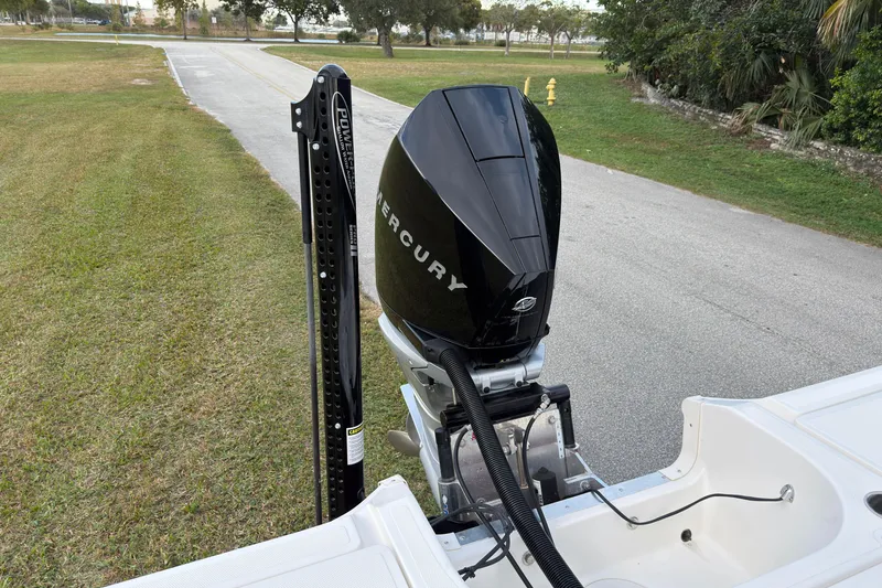 Slide: The Image of 2019 Wellcraft 241 Bay boat with Mercury outboard engine, parked on a grassy area. - 13