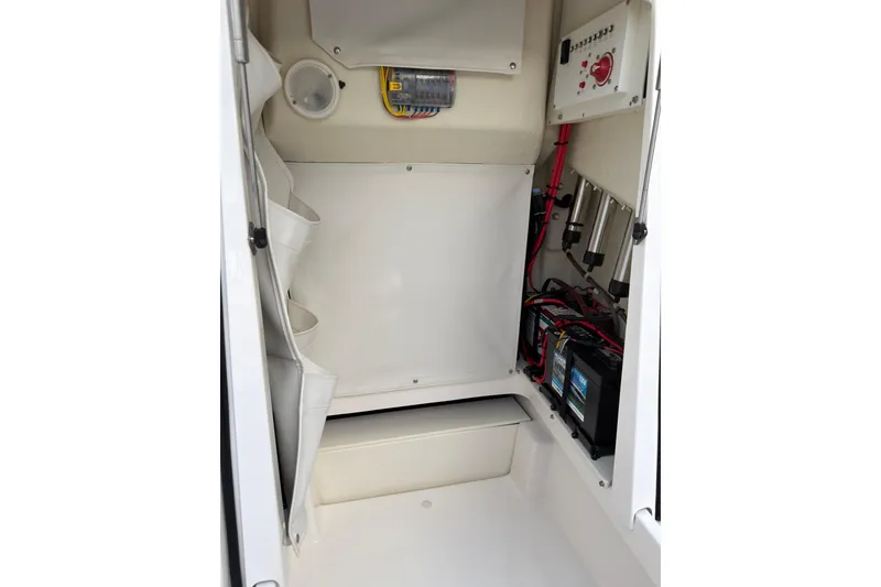 Slide: The Image of 2019 Wellcraft 241 Bay boat interior showing electrical components and storage area. - 27