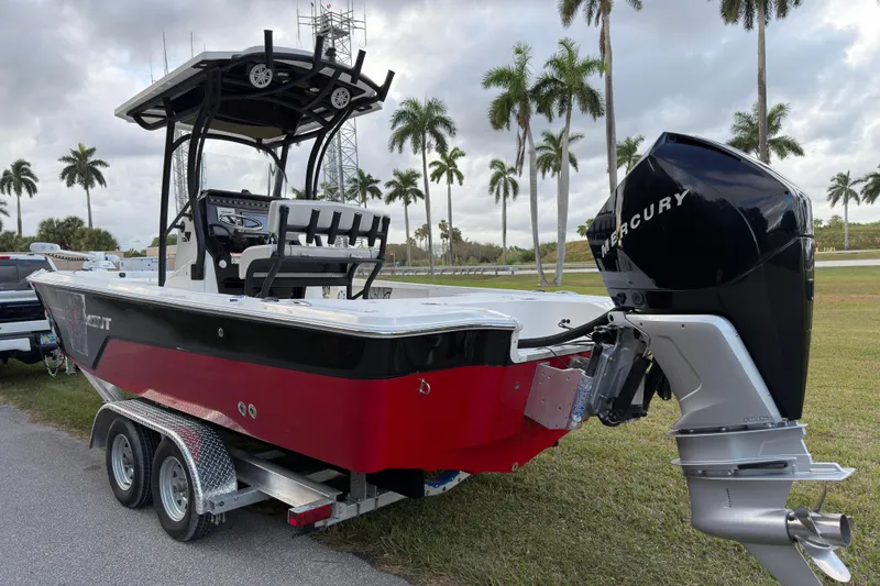 Slide: The Image of 2019 Wellcraft 241 Bay boat on trailer with Mercury engine, parked near palm trees. - 5