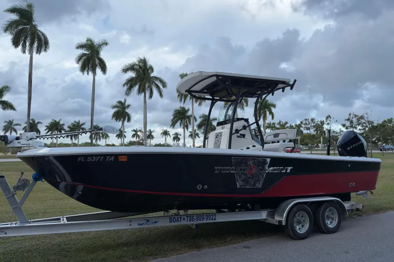 Slide: The Image of 2019 Wellcraft 241 Bay boat on trailer with palm trees in the background. - 7