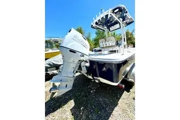 Slide: The Image of 2022 Seapro 228 Bay boat with outboard motor, parked outdoors on gravel. - 13