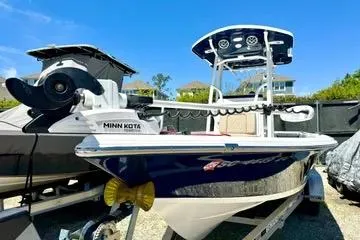 Slide: The Image of 2022 Seapro 228 Bay boat with Minn Kota motor, parked outdoors under clear blue sky. - 2