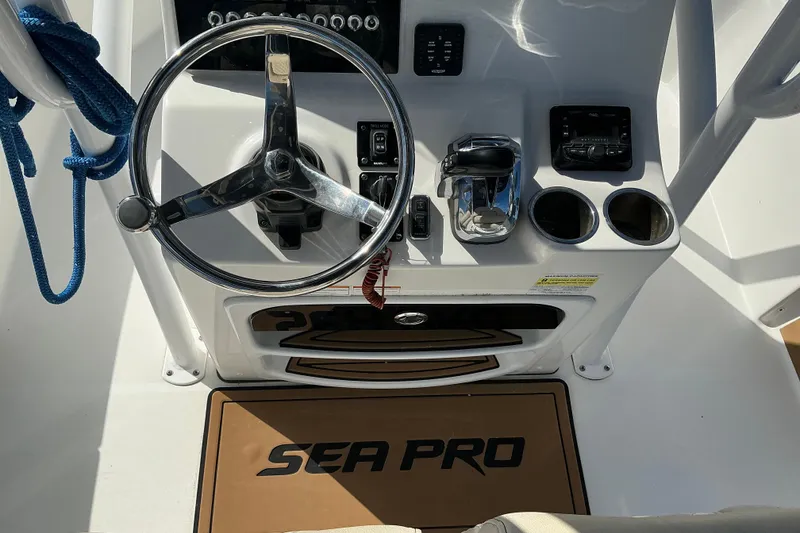 Slide: The Image of 2022 Seapro 228 Bay boat console with steering wheel, controls, and cup holders. - 26