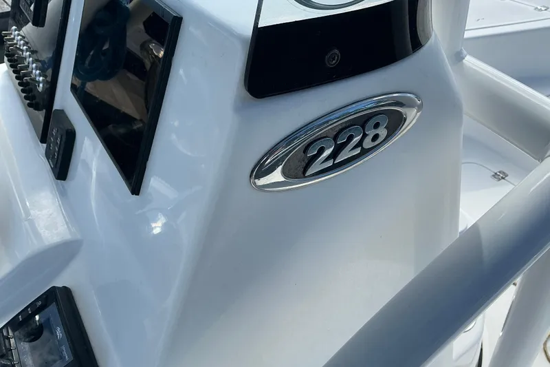 Slide: The Image of 2022 Seapro 228 Bay boat dashboard with model emblem and controls. - 36