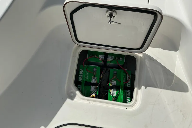 Slide: The Image of Open battery compartment on 2022 Seapro 228 Bay boat showing green batteries. - 39