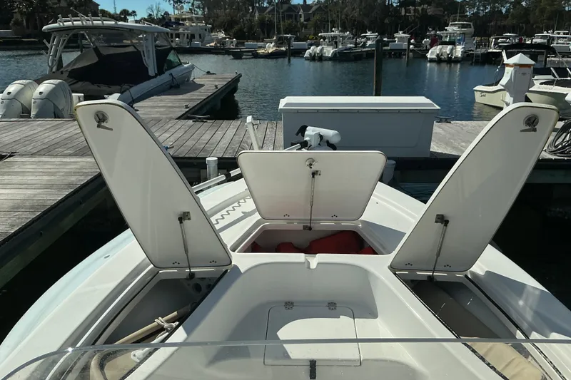 Slide: The Image of 2022 Seapro 228 Bay boat with open storage compartments at a marina dock. - 41
