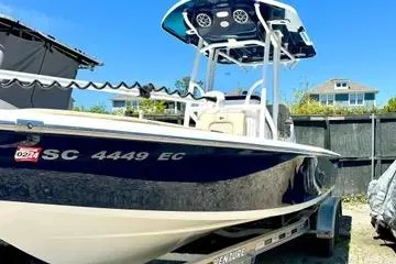 Slide: The Image of 2022 Seapro 228 Bay boat with blue hull and T-top in a sunny outdoor setting. - 5