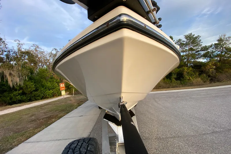 Slide: The Image of 2020 Pathfinder 2500 Hybrid boat on trailer, parked near trees and road. - 11