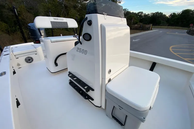 Slide: The Image of 2020 Pathfinder 2500 Hybrid boat interior with seating and console, parked outdoors. - 37