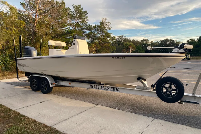 Slide: The Image of 2020 Pathfinder 2500 Hybrid boat on trailer in parking lot, surrounded by trees. - 4