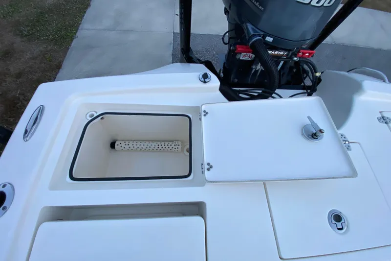 Slide: The Image of 2020 Pathfinder 2500 Hybrid boat with open storage compartments and outboard motor. - 67