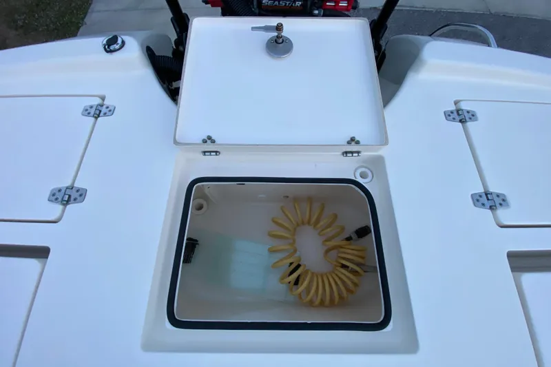 Slide: The Image of 2020 Pathfinder 2500 Hybrid boat storage compartment with coiled hose. - 70