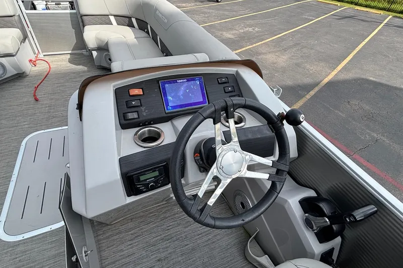 Slide: The Image of 2023 Bennington 23 SXSB boat dashboard with steering wheel and navigation display. - 12
