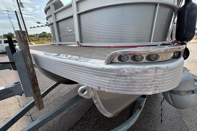 Slide: The Image of 2023 Bennington 23 SXSB pontoon boat on trailer, showing front detail and wear. - 4