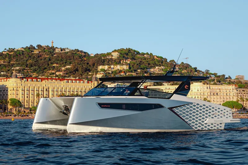 The Image of 2026 Dracan 42 Catamaran cruising near scenic coastal city backdrop. - 0