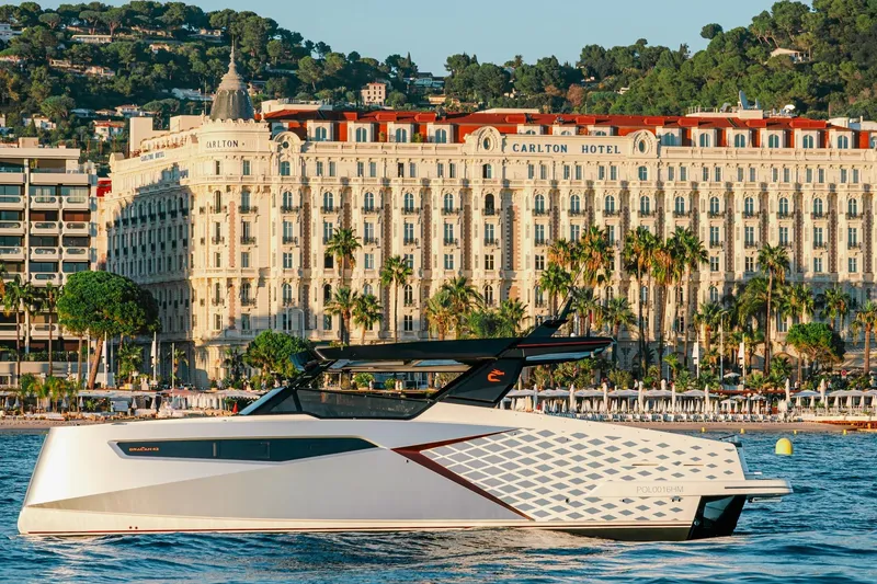 Slide: The Image of 2026 Dracan 42 Catamaran cruising near Carlton Hotel, scenic coastal backdrop. - 1