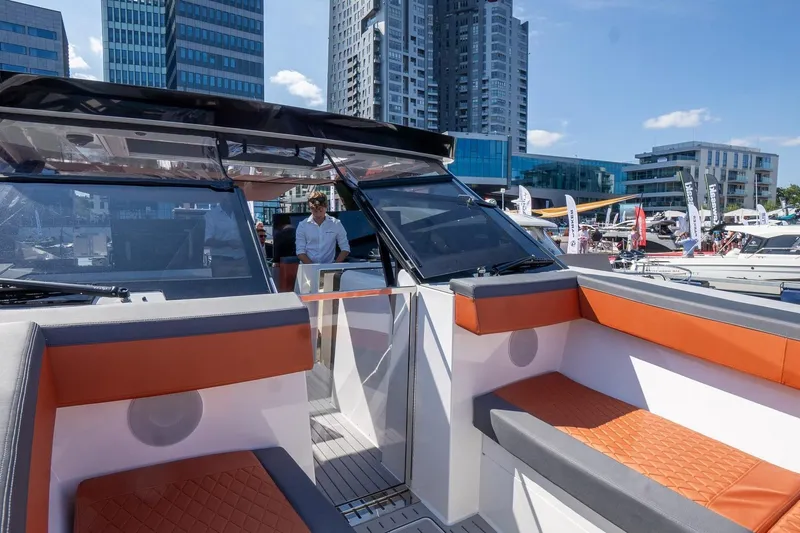 Slide: The Image of 2026 Dracan 42 Catamaran with modern seating, docked near urban skyscrapers. - 9