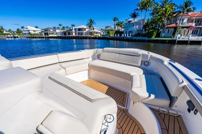 Slide: The Image of Luxurious 2024 Tiara Yachts 48 LS with spacious seating, docked by waterfront homes. - 24