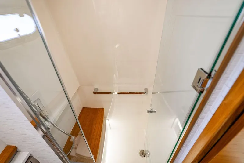 Slide: The Image of 2024 Tiara Yachts 48 LS shower interior with glass door and wooden accents. - 43