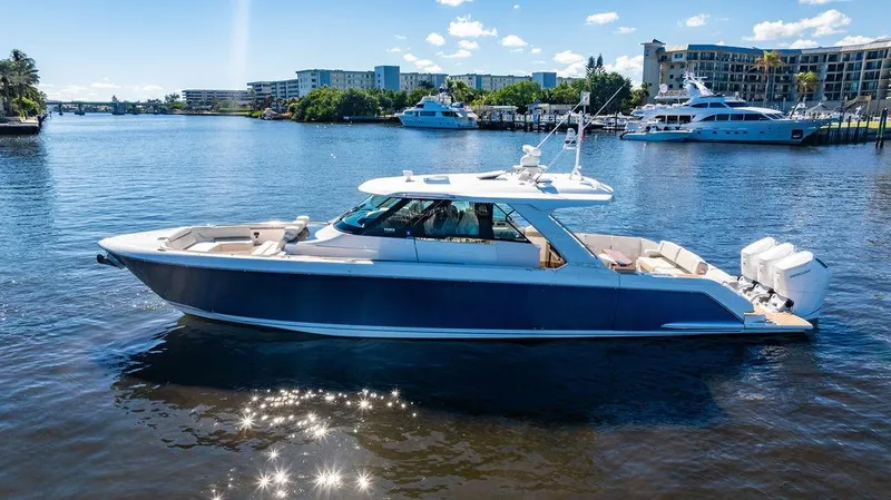 Slide: The Image of 2024 Tiara Yachts 48 LS luxury boat on a sunny waterfront. - 5