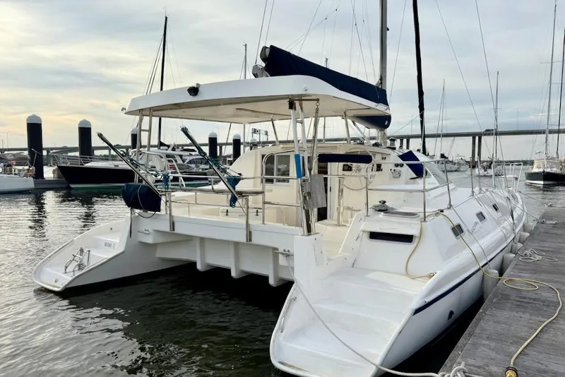 Slide: The Image of 2006 Island Spirit 401 catamaran docked at marina, showcasing spacious deck and sleek design. - 2
