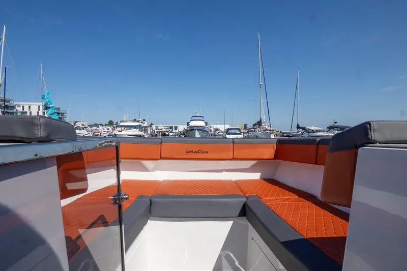 Slide: The Image of 2026 Dracan 42 Catamaran with orange seating, docked in a marina under clear blue skies. - 12