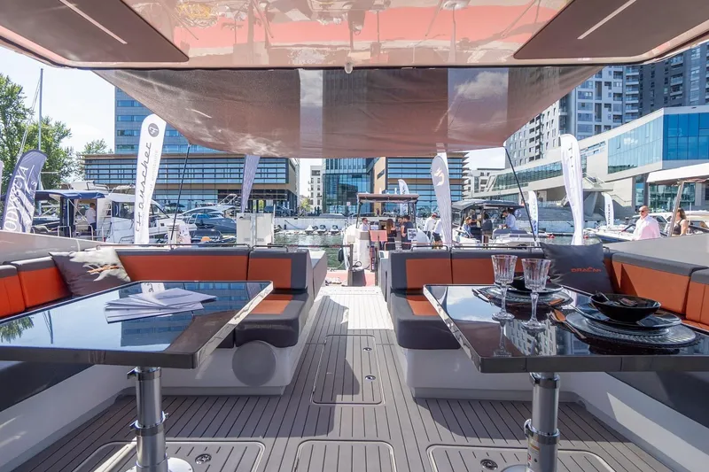 Slide: The Image of Luxurious 2026 Dracan 42 Catamaran interior with elegant seating and dining area at a marina. - 13