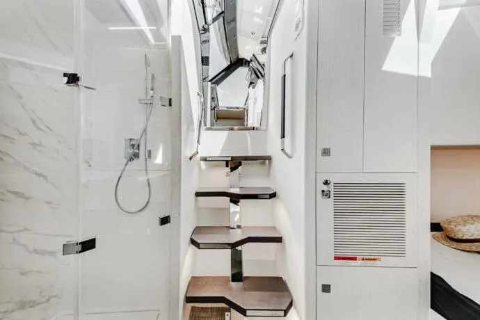 Slide: The Image of Modern interior of 2026 Dracan 42 Catamaran with sleek staircase and shower area. - 34