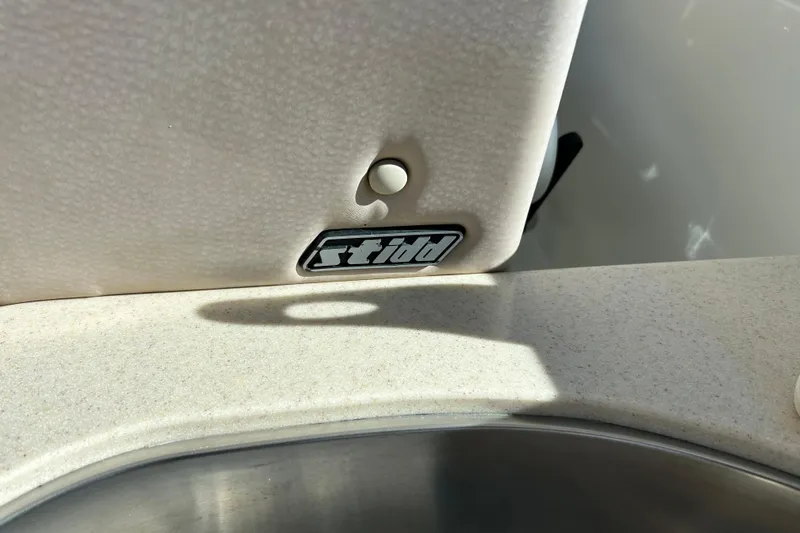 Slide: The Image of Captain's chair on 2008 Back Cove 33 boat, with wooden cabinetry and flooring. - 10