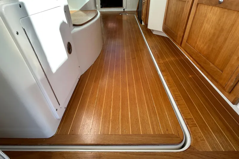 Slide: The Image of 2008 Back Cove 33 boat deck with wooden flooring and white seating, overlooking water. - 20