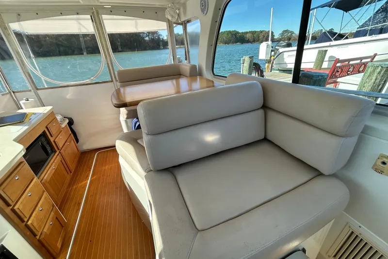 Slide: The Image of 2008 Back Cove 33 boat with cushioned seating and wooden deck by the water. - 21