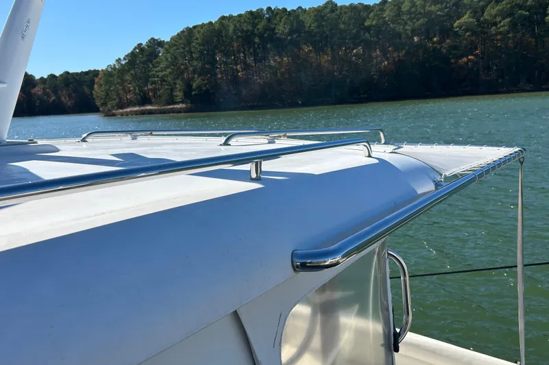 Slide: The Image of 2008 Back Cove 33 boat docked on a sunny lake with forested background. - 4