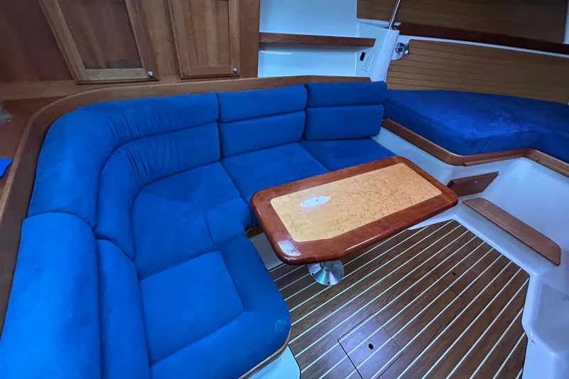 Slide: The Image of 2008 Back Cove 33 interior with blue seating, wooden table, and cozy cabin layout. - 47
