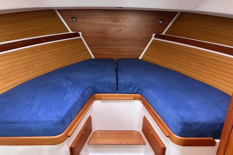 Slide: The Image of 2008 Back Cove 33 interior cabin with blue cushions and wooden paneling. - 48