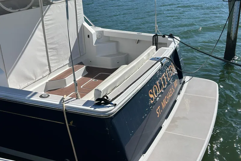 Slide: The Image of 2008 Back Cove 33 boat docked by a scenic lakeside with clear blue skies. - 5