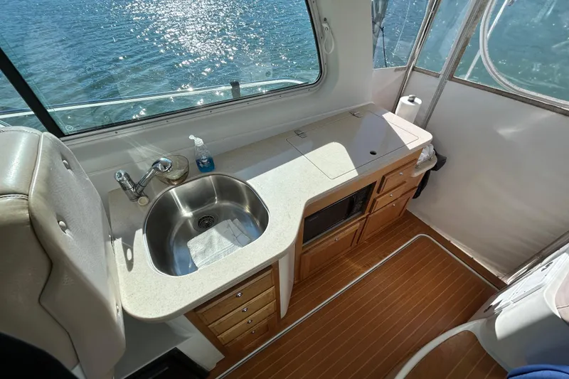 Slide: The Image of Interior of 2008 Back Cove 33 yacht with seating, table, and kitchenette by the water. - 9