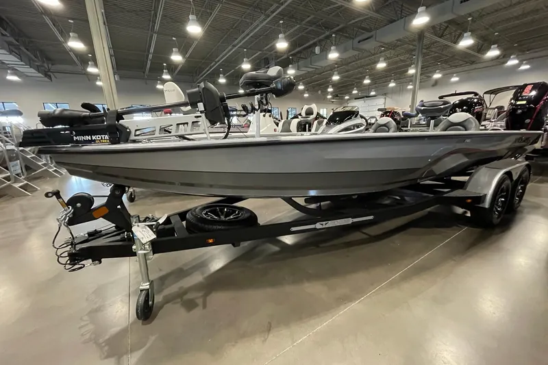 The Image of 2025 Vexus AVX1980C boat on trailer in showroom, featuring Minn Kota Ultrex motor. - 2