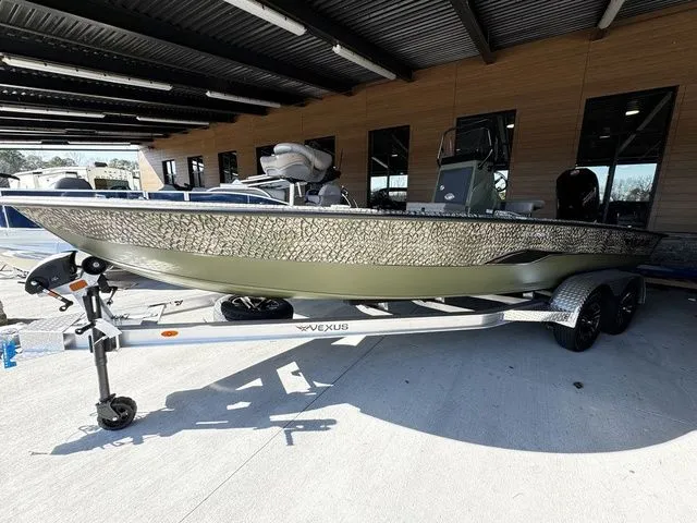 Slide: The Image of 2025 Vexus ACX2150 boat on trailer, parked under a covered area. - 2