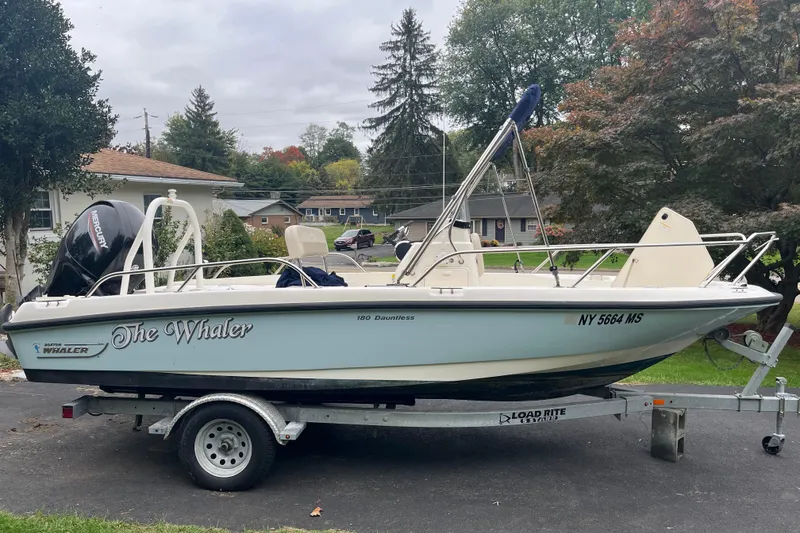 The Image of 2021 Boston Whaler 180 Dauntless boat on trailer in suburban driveway. - 0