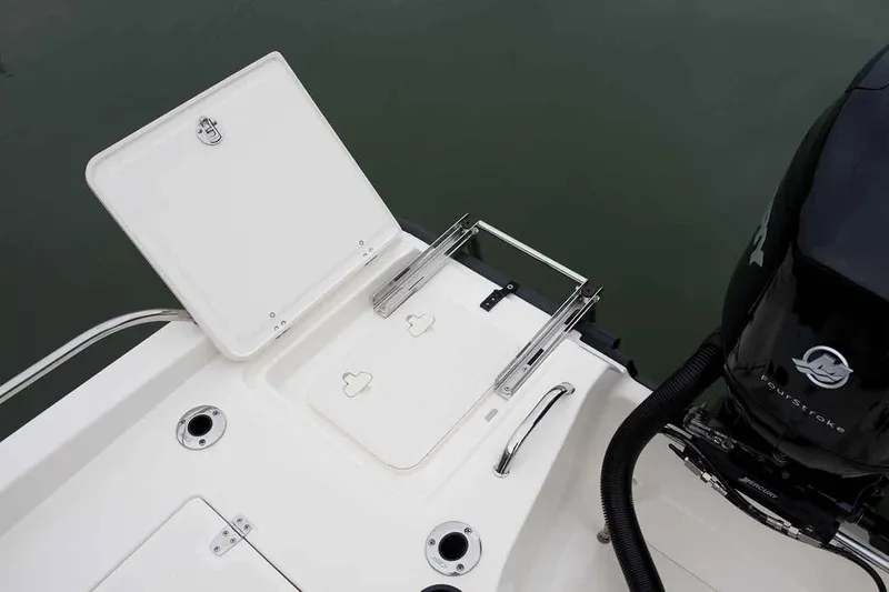 Slide: The Image of Manufacturer Provided Image: 2021 Boston Whaler 180 Dauntless boat with open storage compartment and engine. - 11