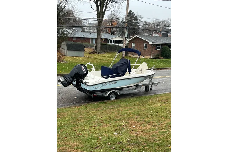 Slide: The Image of 2021 Boston Whaler 180 Dauntless boat on trailer in suburban neighborhood. - 2