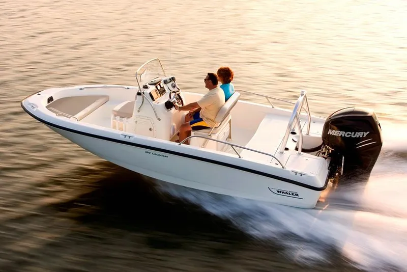 Slide: The Image of Manufacturer Provided Image: 2021 Boston Whaler 180 Dauntless boat cruising on water at sunset. - 6