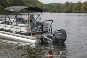 Slide: The Image of 2025 Veranda VR22VLC Tri-Toon boat on a lake with people swimming nearby. - 3