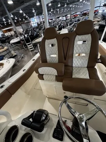 Slide: The Image of 2025 Pioneer Pelagic 270 boat interior with brown and white seating in a showroom. - 10