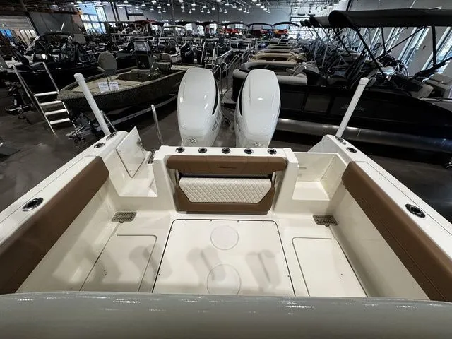 Slide: The Image of 2025 Pioneer Pelagic 270 boat interior with twin engines, showcased in a spacious indoor showroom. - 11