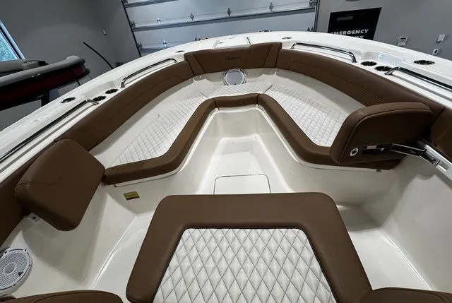 Slide: The Image of 2025 Pioneer Pelagic 270 boat interior with brown cushioned seating and diamond-patterned upholstery. - 7