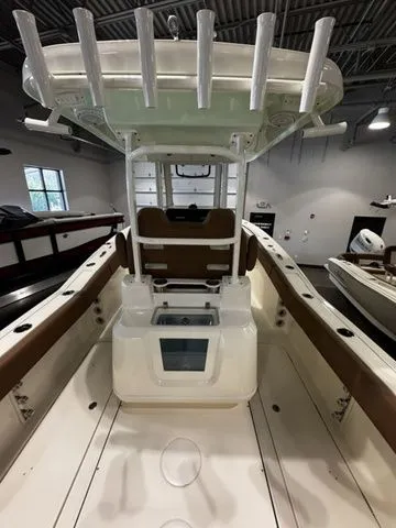 Slide: The Image of 2025 Pioneer Pelagic 270 boat interior with rod holders and seating in a showroom. - 3