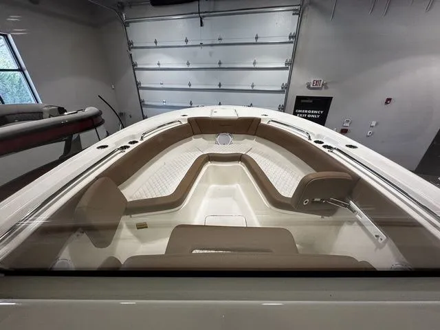 Slide: The Image of 2025 Pioneer Pelagic 270 boat interior with beige seating in a showroom. - 6
