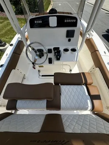 Slide: The Image of 2025 Pioneer ISLANDER 202 boat interior with steering console and cushioned seating. - 7