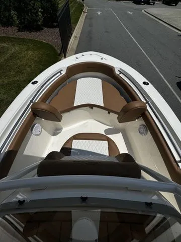 Slide: The Image of 2025 Pioneer ISLANDER 202 boat with brown and white seating, docked on a sunny day. - 8